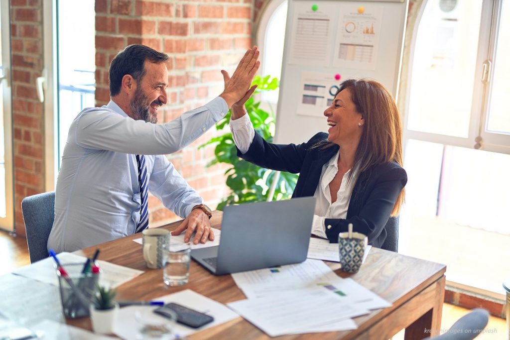 co-workers high five over achievement